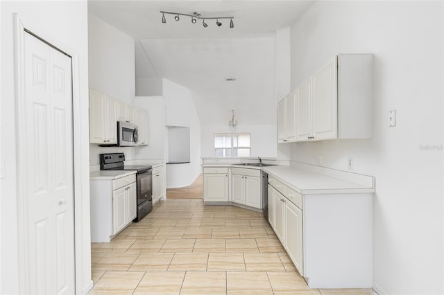 kitchen with sink, stainless steel appliances, white cabinets, vaulted ceiling, and kitchen peninsula