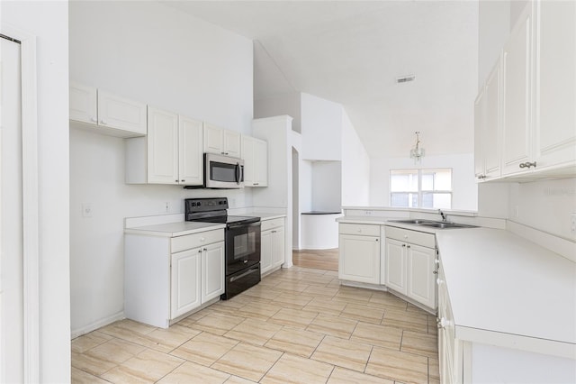 kitchen featuring white cabinetry, black range with electric cooktop, sink, and kitchen peninsula