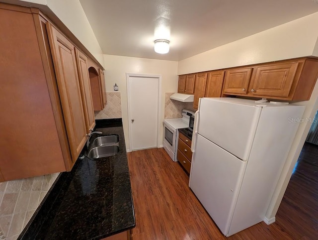 kitchen with stainless steel electric range oven, sink, dark hardwood / wood-style floors, white refrigerator, and dark stone countertops