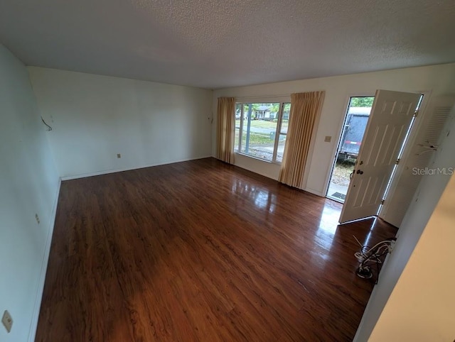 spare room featuring wood-type flooring and a textured ceiling