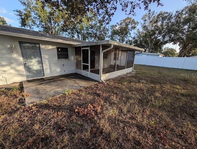 rear view of property featuring a sunroom and a patio