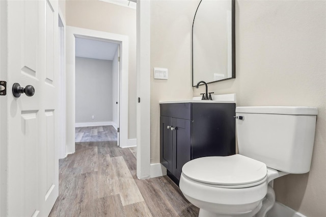 bathroom with hardwood / wood-style floors, vanity, and toilet