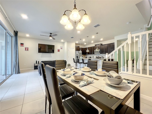 dining space with light tile patterned floors and ceiling fan with notable chandelier