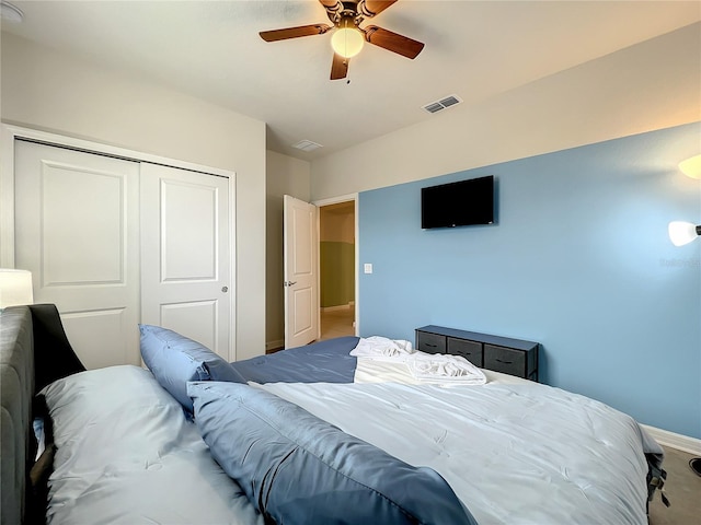 carpeted bedroom featuring ceiling fan and a closet