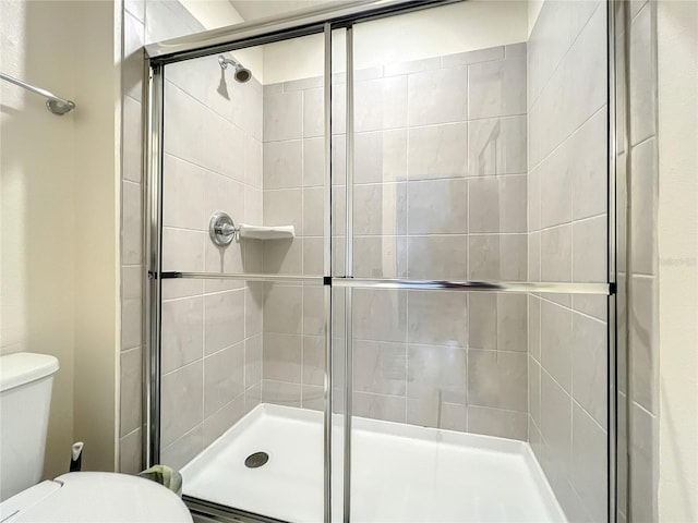 bathroom with an enclosed shower and toilet