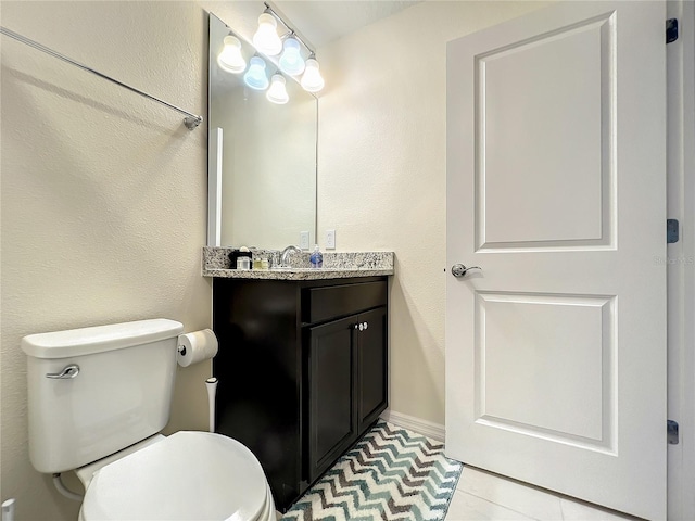 bathroom featuring tile patterned flooring, vanity, and toilet