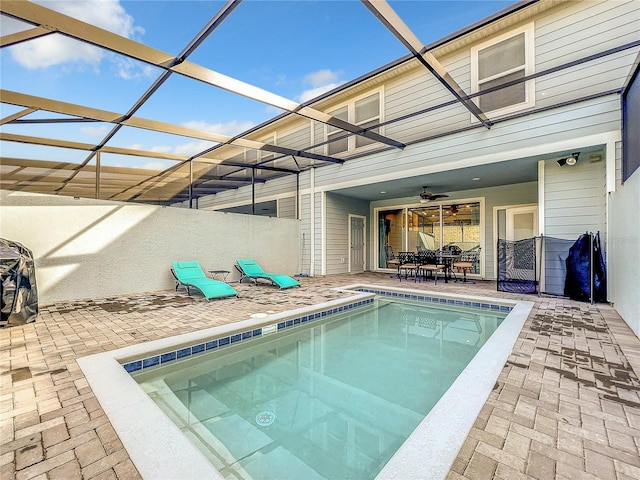 view of swimming pool featuring a lanai, ceiling fan, and a patio area