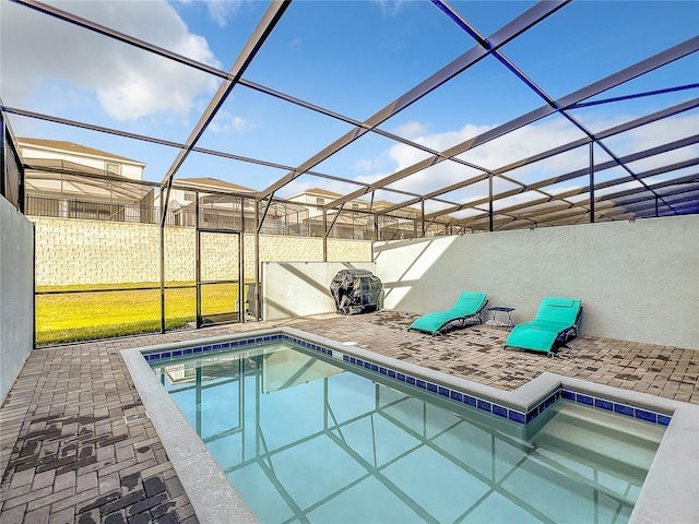 view of swimming pool with glass enclosure and a patio area