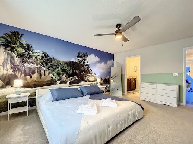 bedroom with light carpet, ensuite bath, and ceiling fan