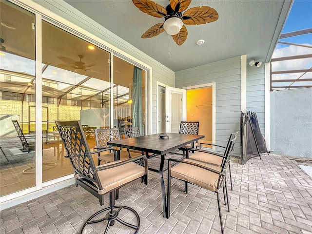 view of patio featuring ceiling fan and a lanai