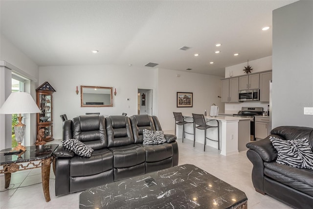 living room featuring light tile patterned floors and vaulted ceiling