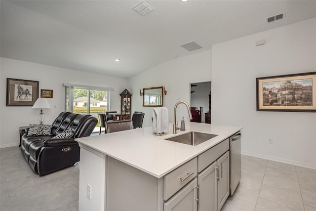 kitchen featuring dishwasher, a center island with sink, sink, vaulted ceiling, and gray cabinets