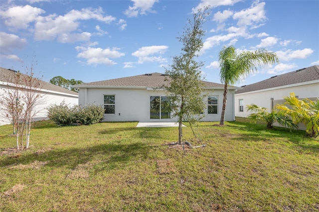 rear view of property with a yard and a patio area