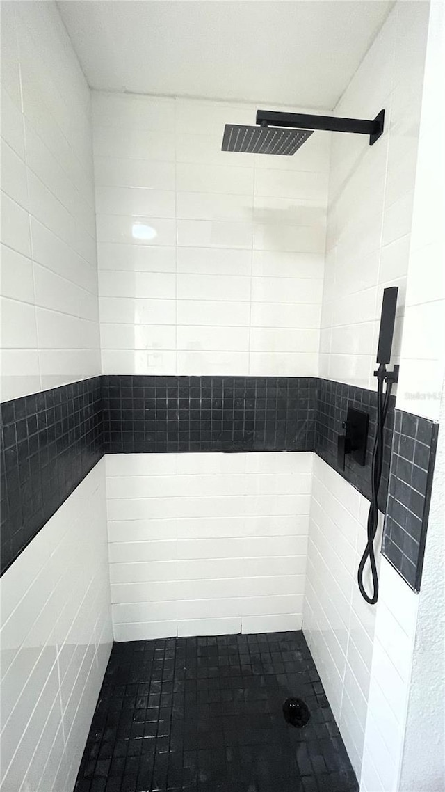 bathroom with a shower and tile walls