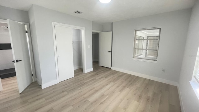 unfurnished bedroom featuring light wood-type flooring and a closet