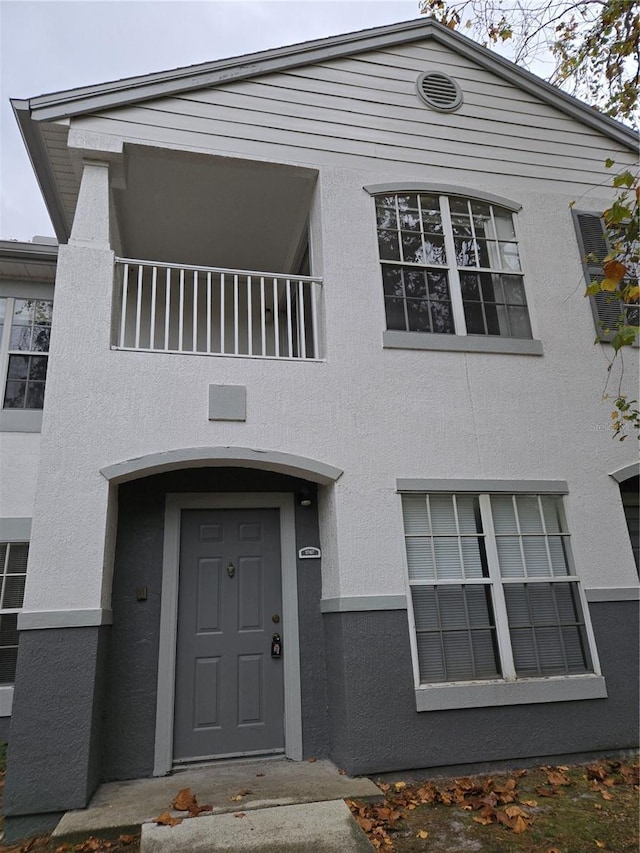 view of exterior entry with a balcony