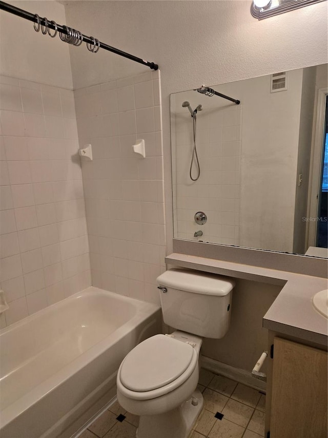 full bathroom with tile patterned floors, vanity, tiled shower / bath combo, and toilet