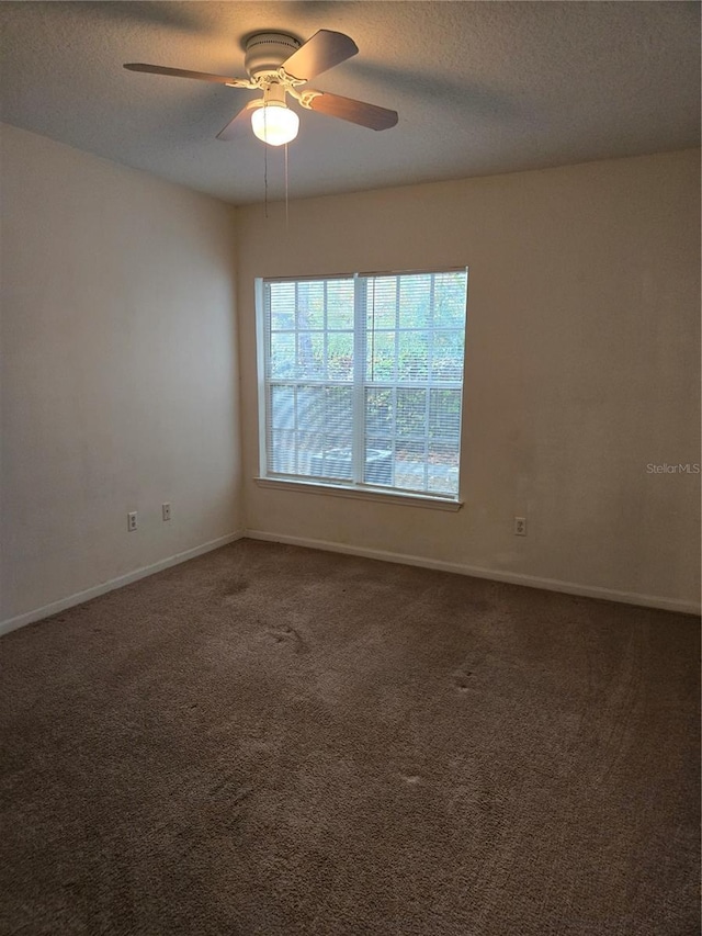 carpeted spare room with ceiling fan and a textured ceiling