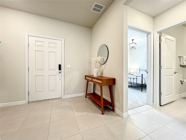 tiled foyer featuring a notable chandelier