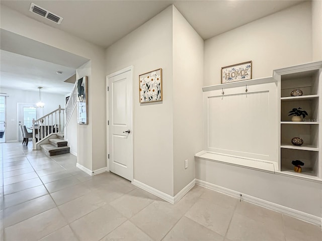 mudroom featuring light tile patterned floors and a chandelier