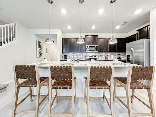 4190 Lana Ave, Davenport, FL 33897 - kitchen featuring stainless steel appliances, backsplash, light stone countertops, a breakfast bar, and recessed lighting