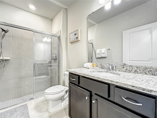 bathroom with tile patterned flooring, vanity, a shower with shower door, and toilet