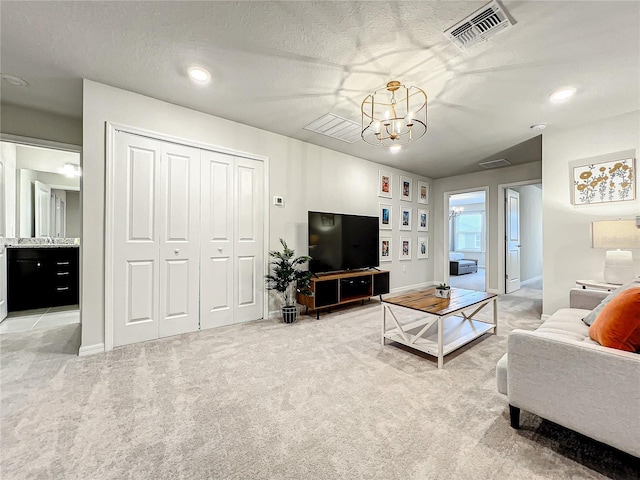 carpeted living room featuring a textured ceiling and an inviting chandelier