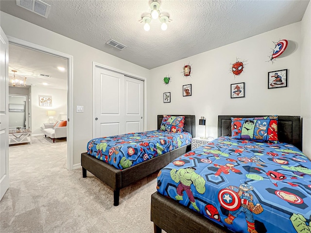 carpeted bedroom with a closet and a textured ceiling