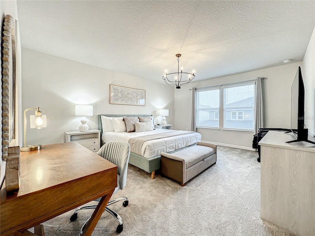 carpeted bedroom featuring a textured ceiling and an inviting chandelier