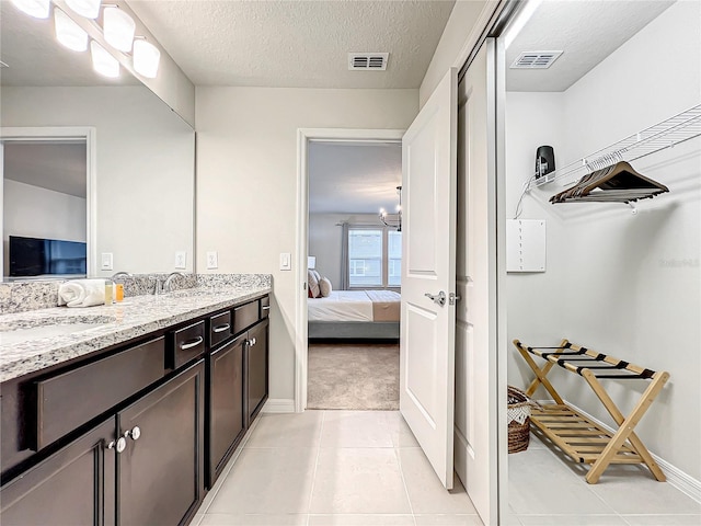 4190 Lana Ave, Davenport, FL 33897 - ensuite bathroom with double vanity, tile patterned floors, and a textured ceiling