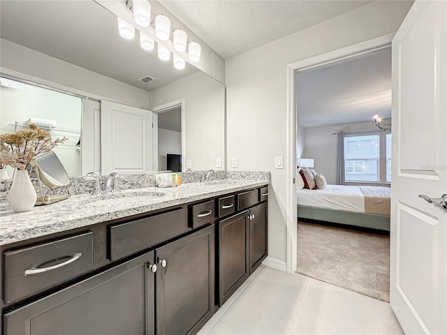 bathroom with tile patterned floors, vanity, and a textured ceiling