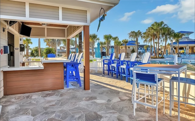 view of patio featuring an outdoor bar and ceiling fan