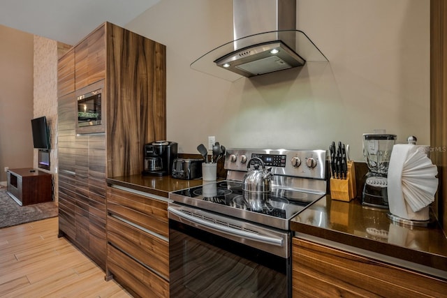 kitchen with island exhaust hood, light wood-type flooring, stainless steel appliances, and stainless steel counters