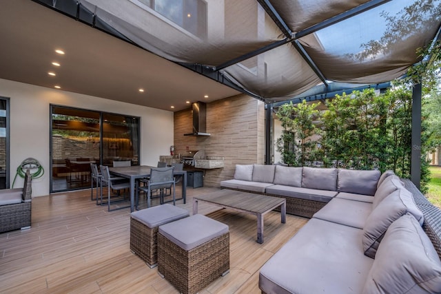 wooden terrace featuring an outdoor kitchen and an outdoor hangout area