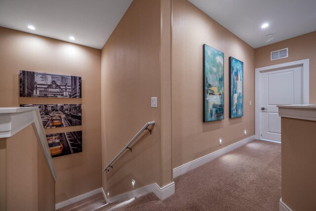 hall with light colored carpet