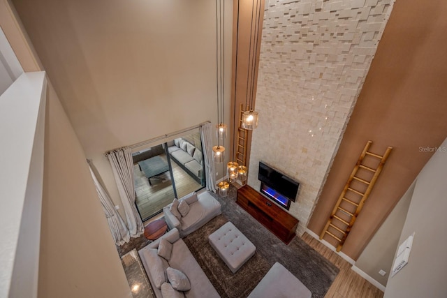 living room with hardwood / wood-style floors and a towering ceiling