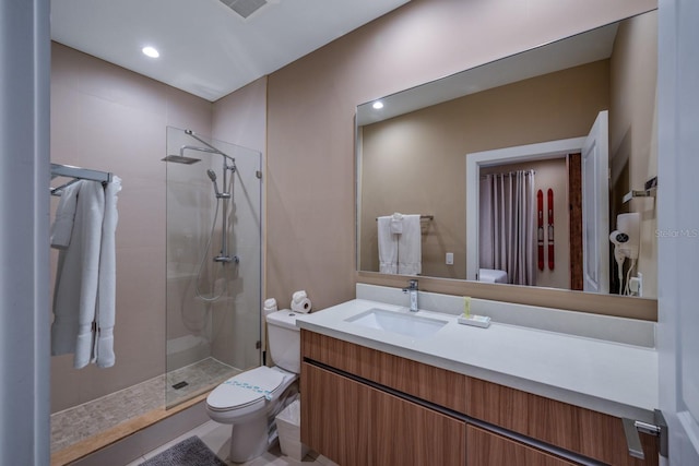 bathroom with a shower with door, vanity, and toilet