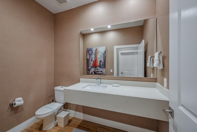 bathroom with hardwood / wood-style flooring, toilet, and sink