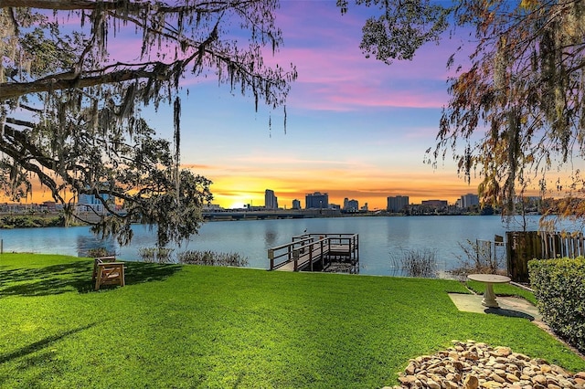 view of dock featuring a lawn and a water view