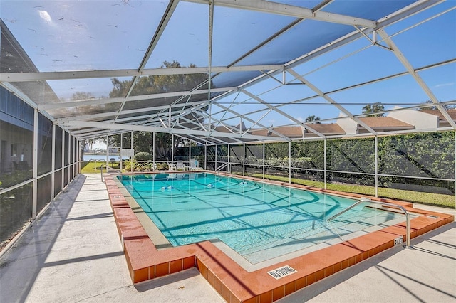 view of swimming pool with glass enclosure and a patio area