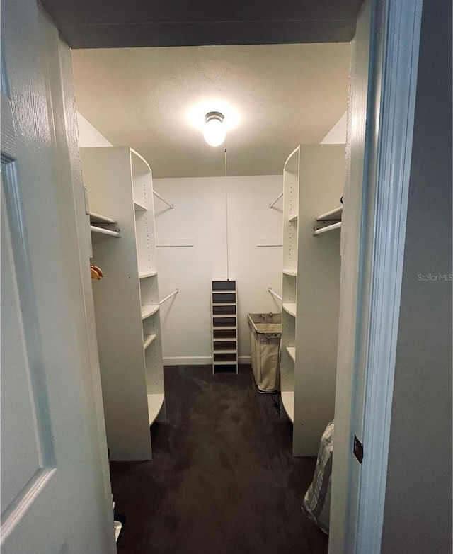 walk in closet featuring dark carpet