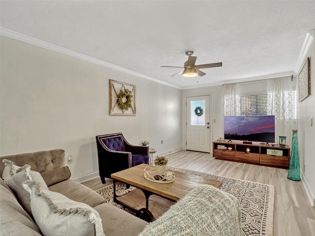 living area featuring ceiling fan, wood finished floors, baseboards, and ornamental molding
