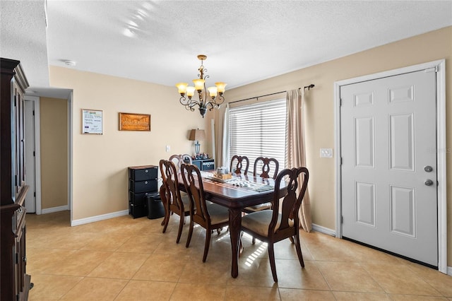 dining room with a chandelier, a textured ceiling, and light tile patterned flooring