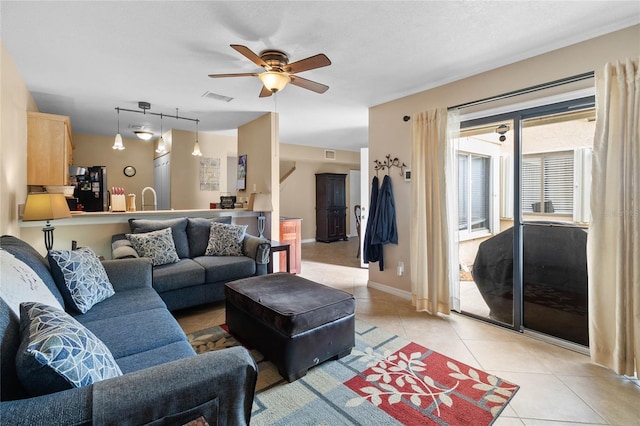 living room with light tile patterned floors, rail lighting, plenty of natural light, and ceiling fan