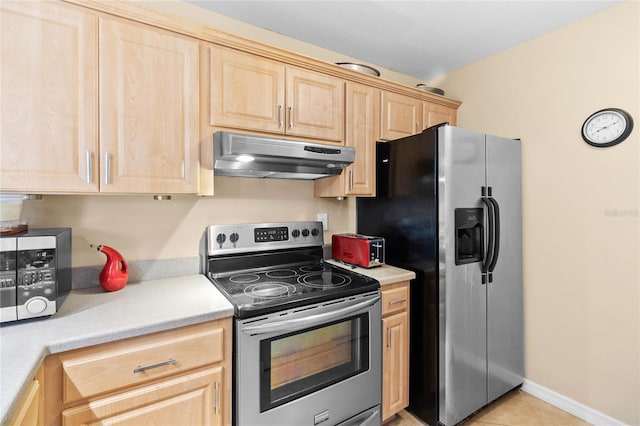 kitchen with light tile patterned floors, stainless steel appliances, and light brown cabinetry