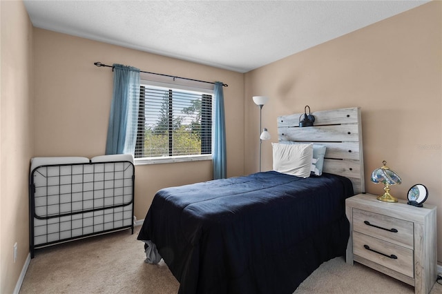 bedroom with light carpet and a textured ceiling