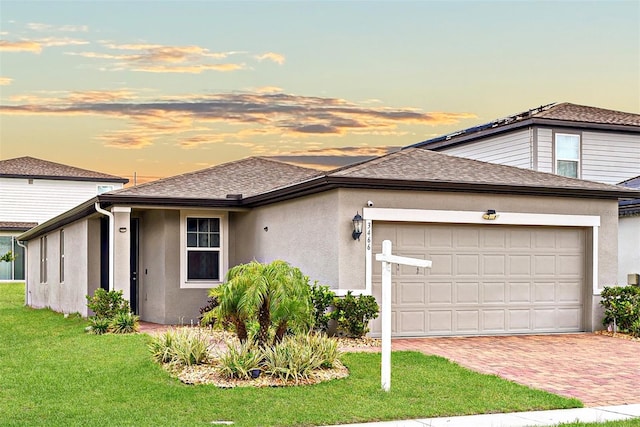 prairie-style house featuring a yard and a garage