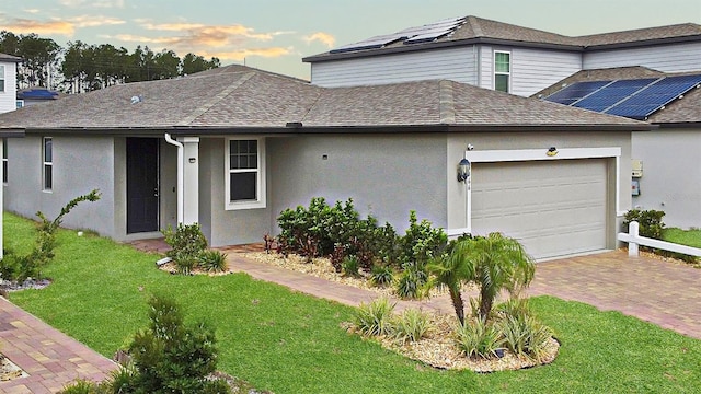 view of front of house featuring a garage and a yard