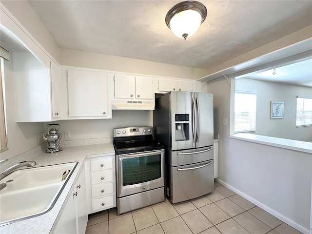 230 Cape Shores Cir Unit 17A, Cape Canaveral, FL 32920 - kitchen featuring stainless steel appliances, under cabinet range hood, light tile patterned floors, white cabinets, and light countertops