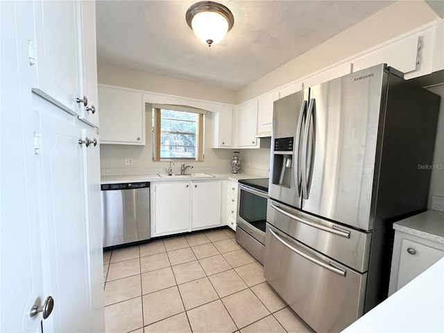 kitchen with white cabinets, light tile patterned floors, sink, and appliances with stainless steel finishes